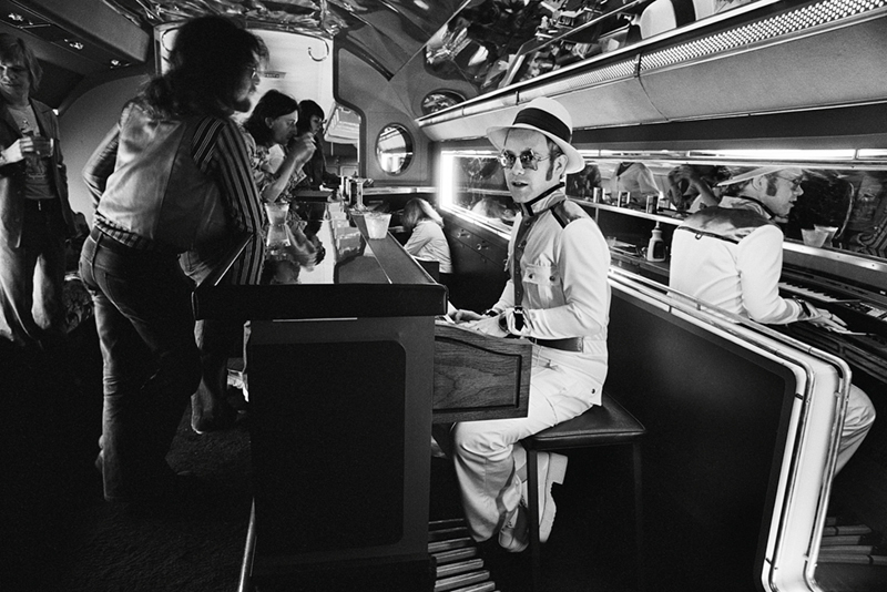 Elton John, Playing Piano on Airplane, 1975